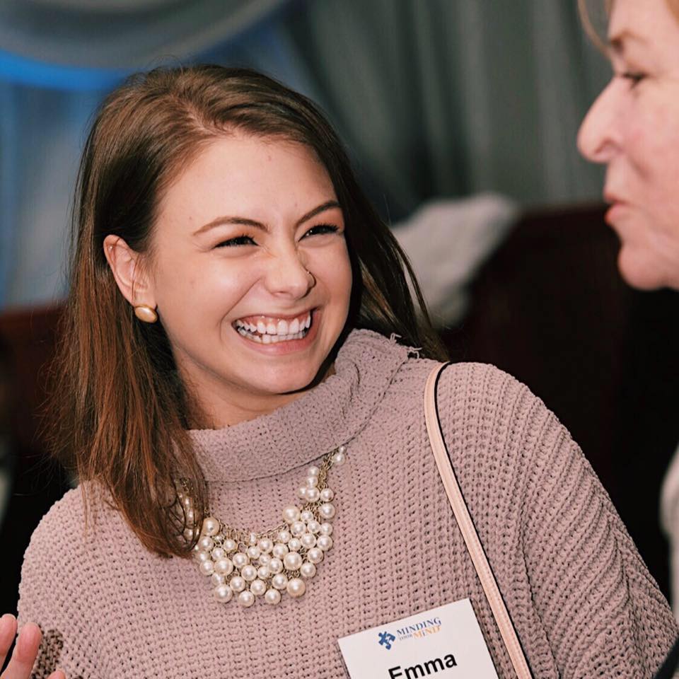 Emma Barrera grins at another individual at a mental health seminar.